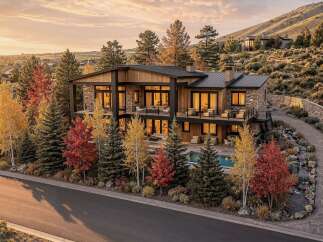 Experience luxury living in this stunning modern home, nestled amidst vibrant autumn foliage and rolling hills.