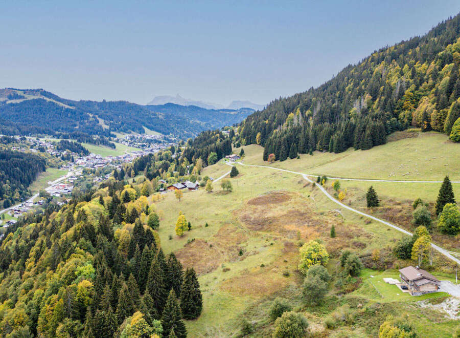 Discover this charming alpine property nestled amidst rolling hills and lush forests, offering breathtaking panoramic views of the surrounding mountains and a picturesque village below.