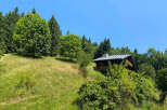 Discover this charming wooden chalet nestled amidst lush greenery and rolling hills, offering a serene mountain retreat.