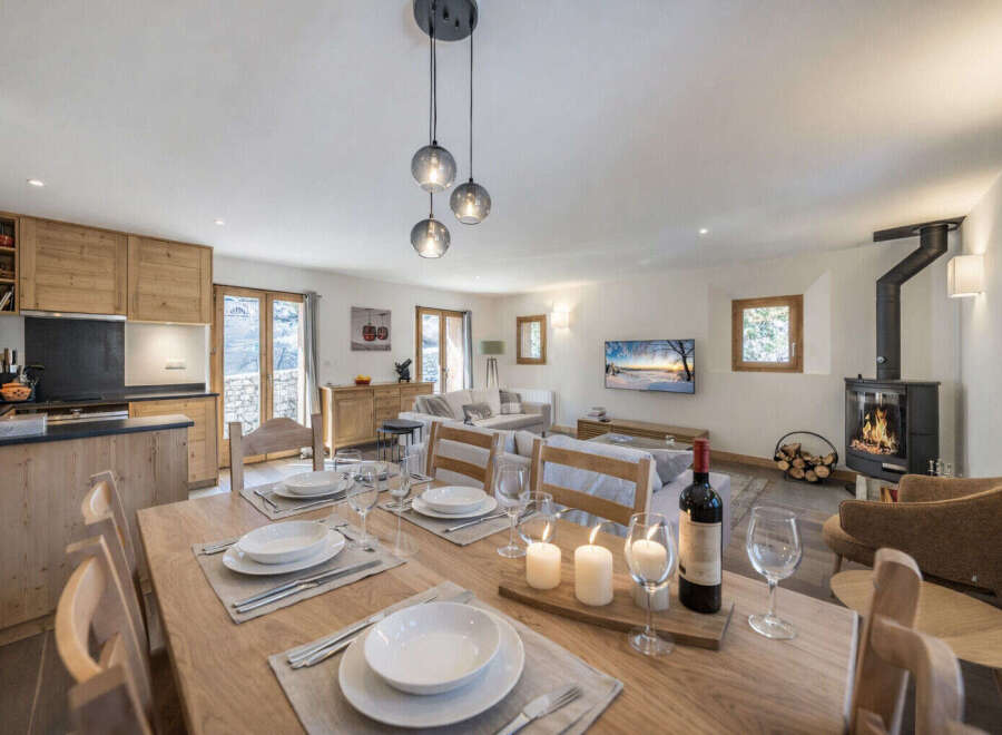 Experience cozy living in this open-plan space, featuring a modern kitchen with wooden cabinetry and a spacious dining area perfect for gatherings.
