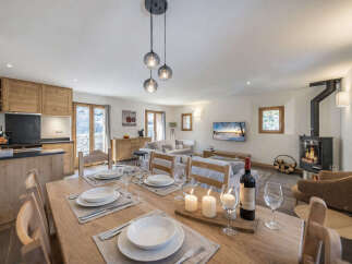 Experience cozy living in this open-plan space, featuring a modern kitchen with wooden cabinetry and a spacious dining area perfect for gatherings.