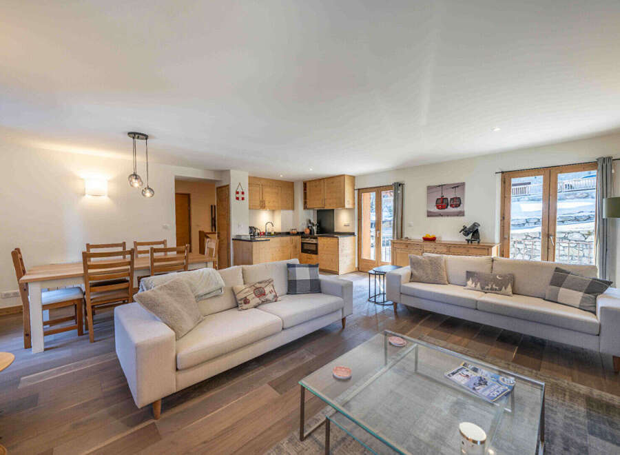 Experience modern living in this spacious open-plan apartment, featuring a fully equipped kitchen with sleek wooden cabinetry and a comfortable living area perfect for relaxation.