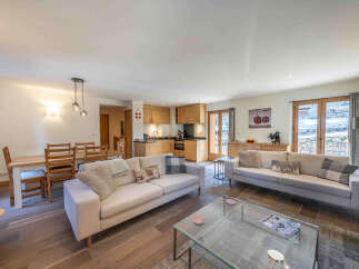 Experience modern living in this spacious open-plan apartment, featuring a fully equipped kitchen with sleek wooden cabinetry and a comfortable living area perfect for relaxation.