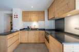 This charming kitchen boasts beautiful natural wood cabinetry, offering a warm and inviting atmosphere.
