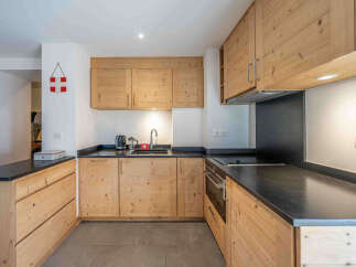 This charming kitchen boasts beautiful natural wood cabinetry, offering a warm and inviting atmosphere.