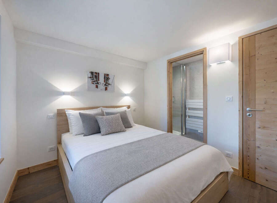 Experience comfort and style in this beautifully appointed bedroom, featuring a plush king-sized bed adorned with soft linens and decorative pillows.