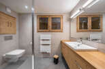 Experience luxury and comfort in this modern bathroom, featuring a sleek wall-mounted toilet and a spacious vanity with ample storage.