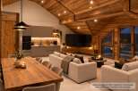 Experience luxurious mountain living in this stunning apartment, featuring a vaulted wooden ceiling and exposed beams that create a warm, alpine ambiance.