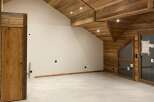 Experience the rustic charm of this unfinished attic space, featuring a stunning wooden beamed ceiling and walls that evoke a cozy mountain lodge feel.