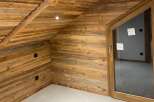 Experience rustic charm and modern comfort in this beautifully appointed room featuring warm, natural wood paneling on the walls and ceiling.
