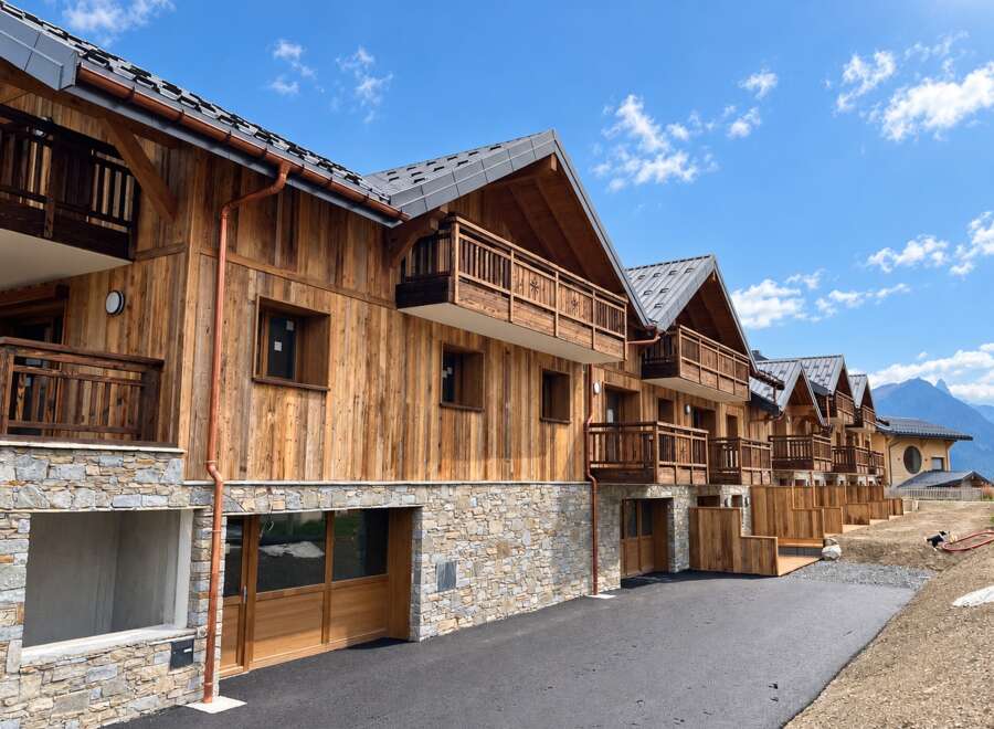 Discover modern alpine living in this stunning new construction featuring a harmonious blend of natural wood and stone.