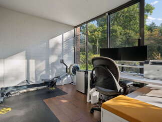 This sun-drenched room offers a versatile space for both work and wellness.