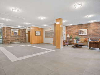 Step into a welcoming lobby featuring a spacious tiled entryway and a comfortable seating area.