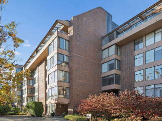 Discover modern living in this stunning apartment building, featuring a striking brick facade and expansive glass windows that flood interiors with natural light.