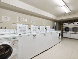 This spacious laundry room features multiple high-efficiency washers and dryers, ensuring quick and convenient laundry days.