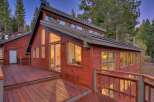 This stunning red wooden home is nestled amongst tall pine trees, offering a serene and private retreat.