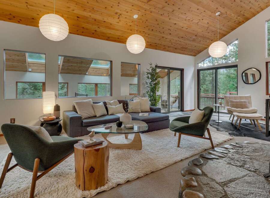 Experience modern living in this stunning home featuring a vaulted wood-paneled ceiling and expansive windows that flood the space with natural light.