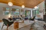 Experience modern living in this stunning home featuring a vaulted wood-paneled ceiling and expansive windows that flood the space with natural light.