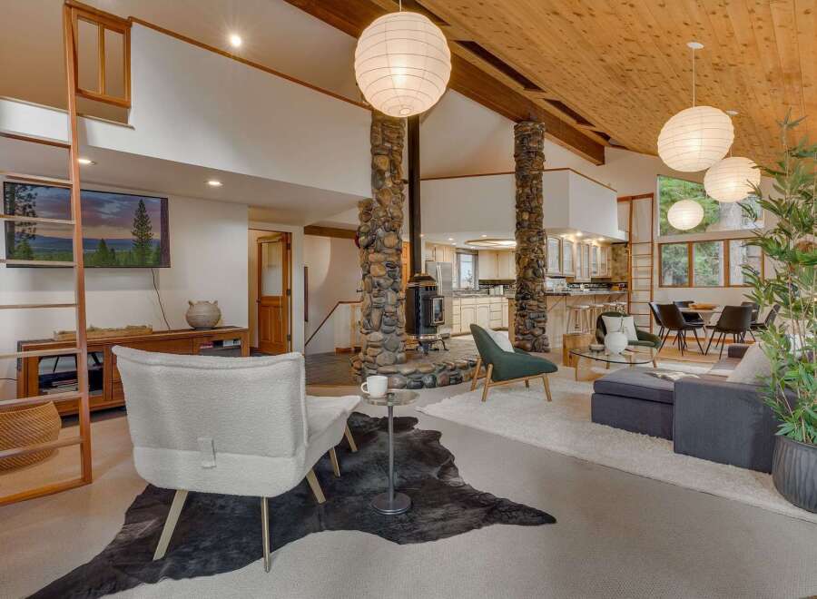Experience rustic charm and modern comfort in this spacious living area, featuring a striking stone fireplace as the centerpiece.