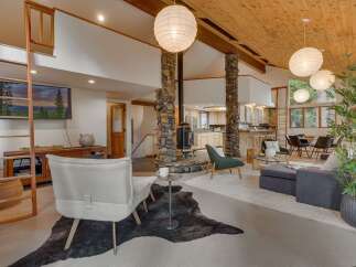 Experience rustic charm and modern comfort in this spacious living area, featuring a striking stone fireplace as the centerpiece.