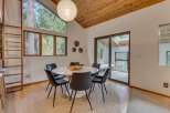 This dining area features a modern white pedestal table surrounded by sleek black chairs, all set on a natural jute rug.