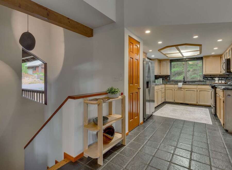 Step into a charming entryway with a unique stone pendant light and a wooden staircase leading to the upper level.
