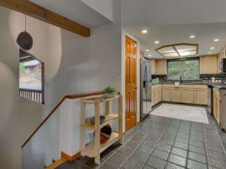 Step into a charming entryway with a unique stone pendant light and a wooden staircase leading to the upper level.