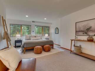 Experience serene living in this beautifully appointed bedroom, featuring a comfortable king-sized bed dressed in neutral linens and accented with plush pillows.
