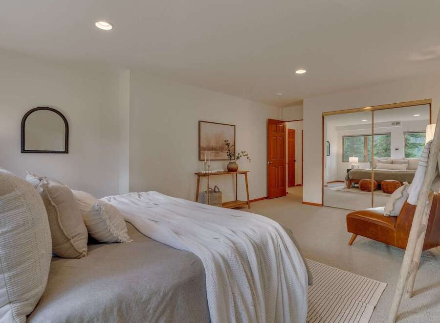 Experience serene living in this beautifully appointed bedroom, featuring a plush bed adorned with textured pillows and a cozy white throw.