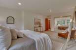 Experience serene living in this beautifully appointed bedroom, featuring a plush bed adorned with textured pillows and a cozy white throw.