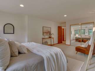 Experience serene living in this beautifully appointed bedroom, featuring a plush bed adorned with textured pillows and a cozy white throw.