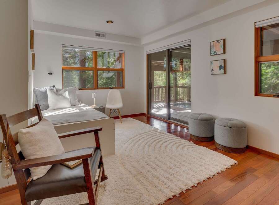 This bedroom offers a serene retreat with a comfortable bed adorned with plush pillows, bathed in natural light from a large window.