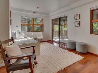 This bedroom offers a serene retreat with a comfortable bed adorned with plush pillows, bathed in natural light from a large window.