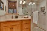 This bathroom features a warm and inviting aesthetic with natural wood cabinetry and a stone countertop.