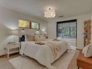 Experience serene living in this beautifully appointed bedroom, featuring a plush white duvet, layered throw blankets, and a cozy shag rug for ultimate comfort.