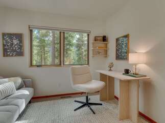 This home office features a comfortable gray sofa with decorative pillows, perfect for a reading nook or a break from work.
