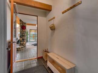 Step into a welcoming entryway featuring a rustic stone fireplace and a charming wooden bench.
