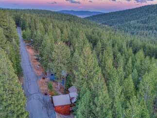 Experience the serene mountain lifestyle with this stunning property nestled amidst a dense forest of towering pine trees.