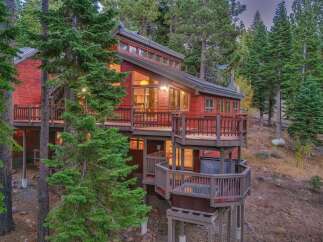 Nestled amidst towering pine trees, this stunning red wood cabin offers a serene mountain retreat.