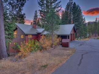 Nestled amongst tall pine trees, this charming wooden home offers a serene mountain retreat.