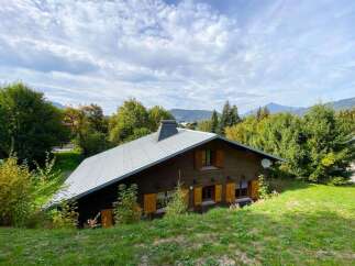 Nestled amidst lush greenery and rolling hills, this charming wooden chalet offers a serene mountain retreat.
