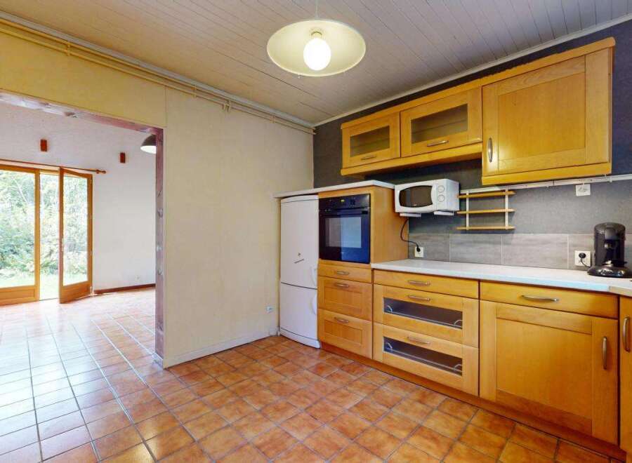 Step into this charming kitchen featuring warm wooden cabinetry and a built-in oven and microwave.