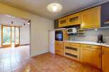 Step into this charming kitchen featuring warm wooden cabinetry and a built-in oven and microwave.