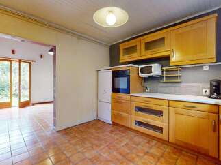 Step into this charming kitchen featuring warm wooden cabinetry and a built-in oven and microwave.