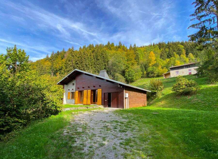 Nestled amidst a vibrant autumn forest, this charming wooden chalet offers a serene mountain retreat.