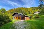 Nestled amidst a vibrant autumn forest, this charming wooden chalet offers a serene mountain retreat.