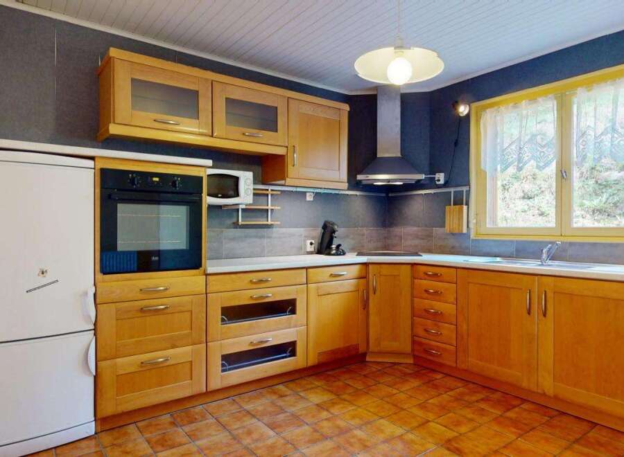 This charming kitchen features warm wooden cabinetry, providing ample storage and a classic aesthetic.