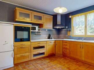 This charming kitchen features warm wooden cabinetry, providing ample storage and a classic aesthetic.