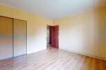 This spacious room features a large built-in wardrobe with light wood sliding doors, offering ample storage solutions.