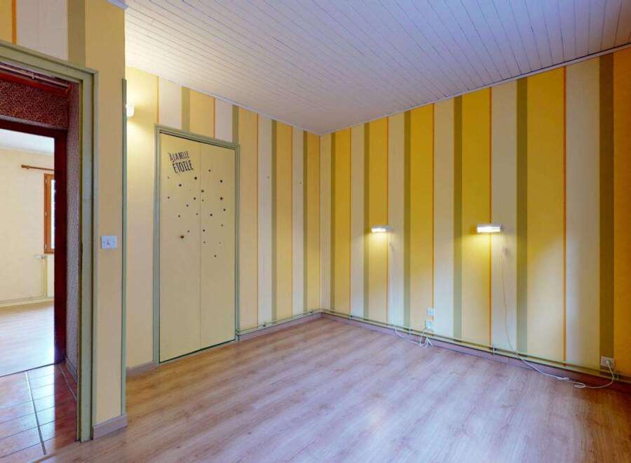 Step into a bright and cheerful room featuring playful yellow and cream striped walls, creating an inviting atmosphere.